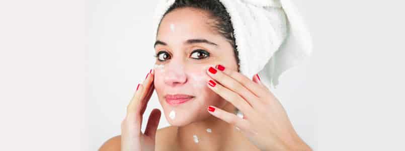 Woman washing and moisturizing face to prevent phentermine acne