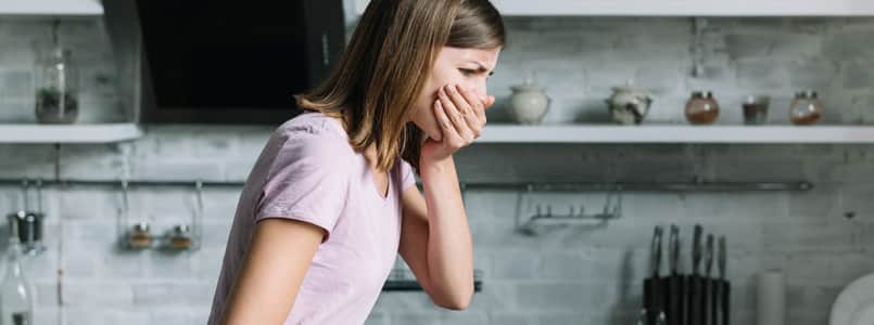 young woman covering her mouth during a wave of nausea