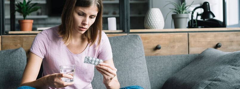 Woman examining a packet of pills