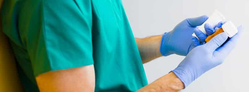 doctor holding two bottles to decide with gloved hands