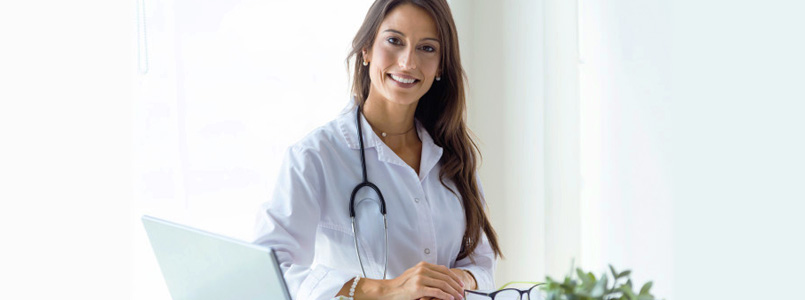 young, female doctor smiling from behind a desk
