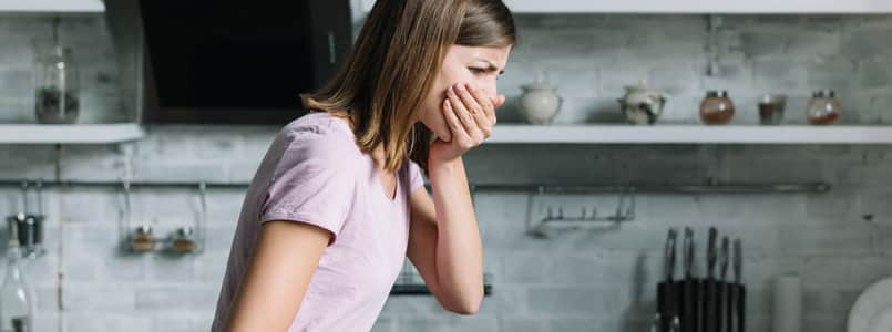 young woman covering her mouth during a wave of nausea