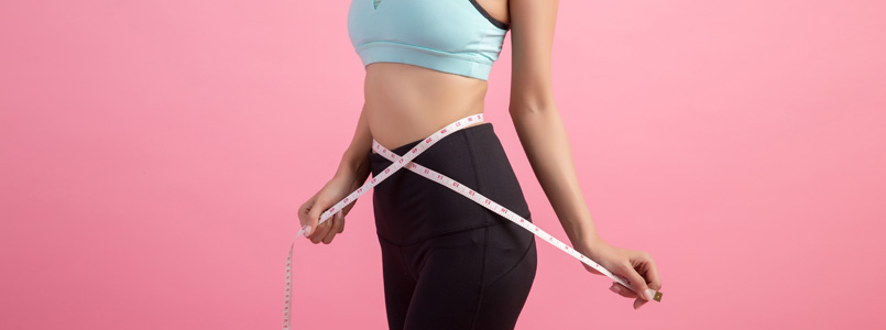 slim woman measuring her waist