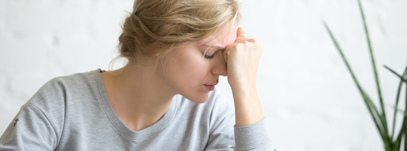 donna con la fronte premuta nel pugno