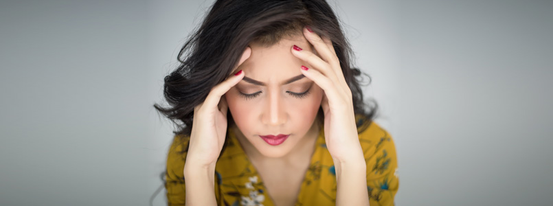 Woman holding her head, suffering from a headache