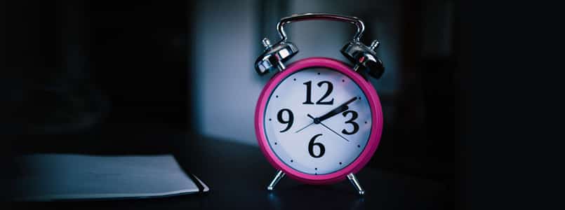 pink alarm clock in dark room