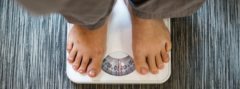 two feet standing on a bathroom scale