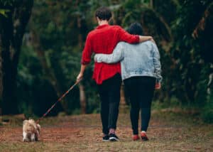 couple walking outdoors with their dog