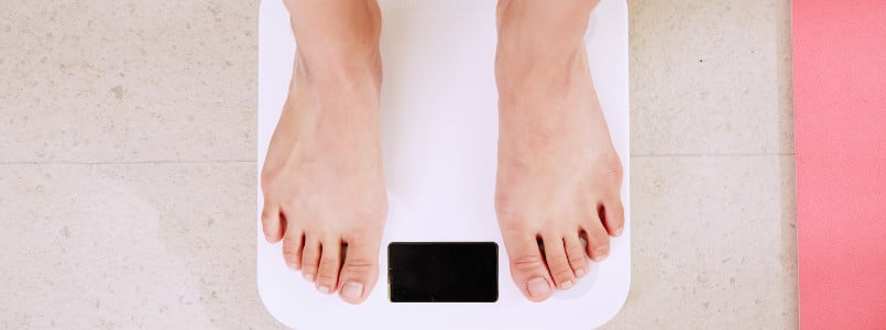 woman weighing herself on a scale